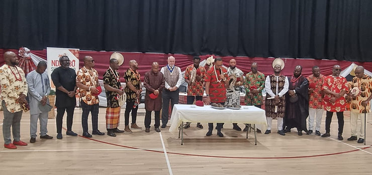 Cross-section of titled and untitled men performing the cutting of the new yam